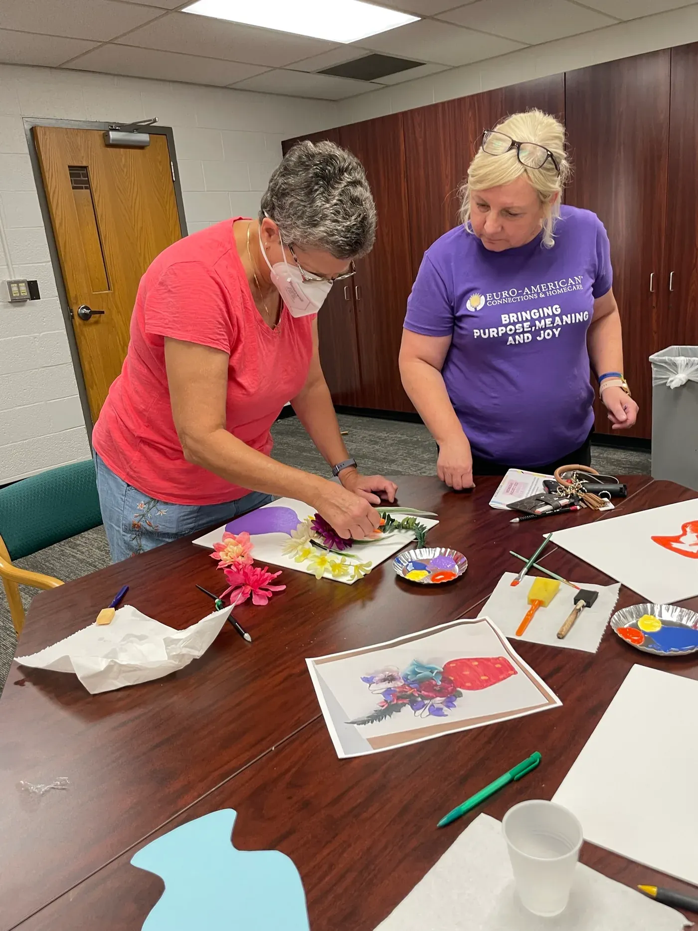 Beata teaching a painting technique at a senior center