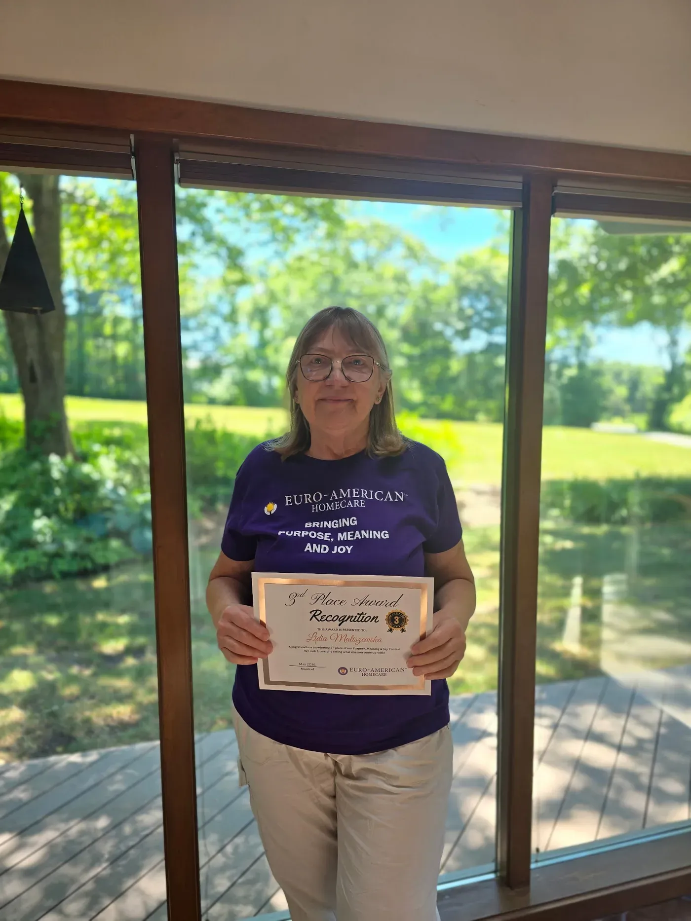 A caregiver receiving a certificate and a gift card