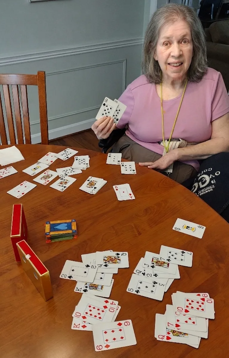 A client smiling while playing cards during July's third-place Moments of Joy activity